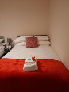 a bedroom with a white bed with a red blanket at Matipa-Rise Guest House Southampton in Southampton