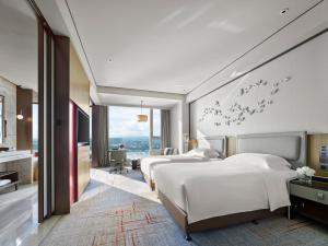 ein Hotelzimmer mit vier Betten mit Vögeln an der Wand in der Unterkunft InterContinental Quanzhou, an IHG Hotel in Quanzhou