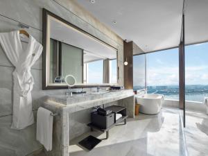 a bathroom with a sink and a tub and a mirror at InterContinental Quanzhou, an IHG Hotel in Quanzhou