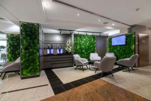 a waiting room with a green wall at Aparthotel Vanilla in Kraków