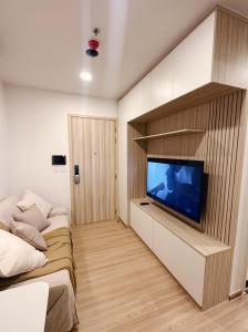 a living room with a flat screen tv on a wall at Prach-Chewa BKK Kaset-Nawamin in Bangkok
