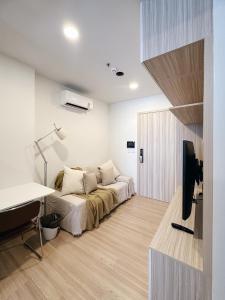 een slaapkamer met een bed, een bureau en een televisie bij Prach-Chewa BKK Kaset-Nawamin in Bangkok