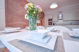 uma mesa branca com um vaso de flores em Stylish 2BR Designer Flat Holland Park em Londres