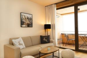 a living room with a couch and a table at Heimat 1495m Appartements TYP 1 in Schröcken