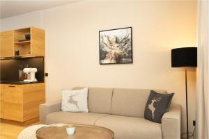 a living room with a couch and a table at Heimat 1495m Appartements TYP 1 in Schröcken