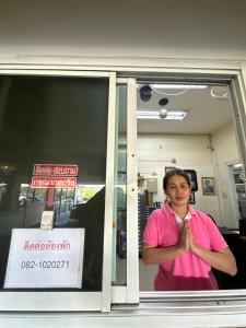 a man in a pink shirt standing in a window at นวนคร ออมสินอพาร์ตเมนต์ ติดห้างบิกซี Navanakorn Aomsin hotel near shopping mall,snooker and club in Ban Lam Rua Taek