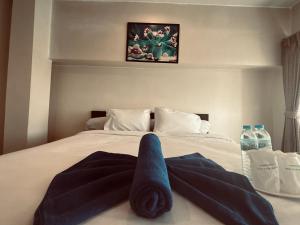 uma cama com uma toalha azul em นวนคร ออมสินอพาร์ตเมนต์ ติดห้างบิกซี Navanakorn Aomsin hotel near shopping mall,snooker and club em Ban Lam Rua Taek