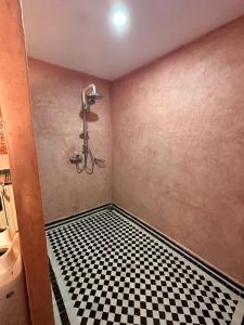 a bathroom with a black and white checkered floor at Gîte d'étape Tamaloute in Bou Drarar