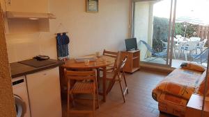 eine Küche mit einem Tisch und eine kleine Küche mit einem Tisch und Stühlen in der Unterkunft Joli studio cabine bord de mer avec piscine - 4FR503 in Saint-Cyprien