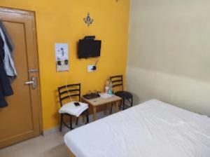a bedroom with a bed and a table and chairs at Hotel Akashdeep, Ranchi in Rānchī