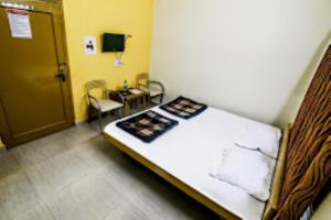 a room with a bed and a table and a door at Hotel Akashdeep, Ranchi in Rānchī
