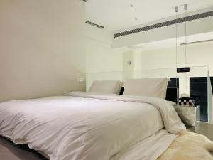 1 cama blanca grande con sábanas y almohadas blancas en 重庆山川的民宿, en Chongqing