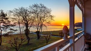 Seeschloss, App 27 - direkt an der Strandpromenade, TOPLAGE في بينز: إطلالة على المحيط من شرفة مع غروب الشمس