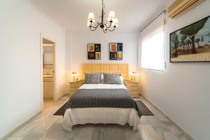 a bedroom with a large bed and a chandelier at Victoria 5 Apartment in Seville