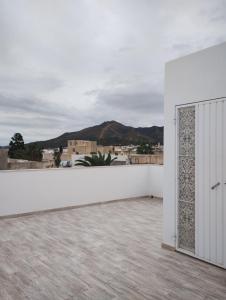 een uitzicht vanaf het dak van een huis met een witte muur bij Appartement Les Cyclamens Hammam Lif Tunisie in Hammam-Lif
