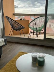 um quarto com uma mesa e 2 cadeiras numa varanda em Cozy apartment with balcony 1 minute from the sea / Appartement T2 cosy avec balcon à 1 min de l'océan em Capbreton