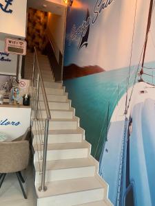 uma escada num quarto com um barco pintado na parede em Sleeping Sailor Boutique Hotel em Siófok