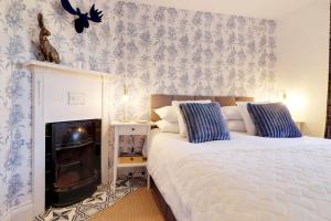1 dormitorio con 1 cama y chimenea con papel pintado azul y blanco en Pass the Keys Cute flat in Tonbridge, en Tonbridge