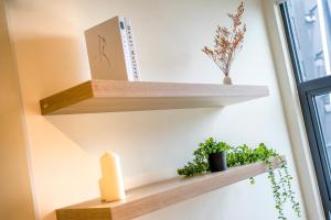 a shelf with plants and a candle on a wall at Arte Mont Kiara Free Parking, Kuala Lumpur in Kuala Lumpur