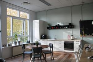 a kitchen with a table and chairs in a room at Het Lokaal in Cornjum