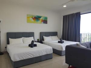 a hotel room with two beds and a couch at Miko's studio at Trefoil Setia Alam in Setia Alam