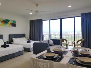 a hotel room with two beds and a living room at Miko's studio at Trefoil Setia Alam in Setia Alam