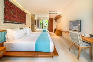 a bedroom with a large bed and a desk at IZE Canggu by LifestyleRetreats in Canggu