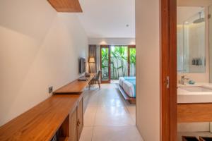 a bathroom with a sink and a bed in a room at IZE Canggu by LifestyleRetreats in Canggu