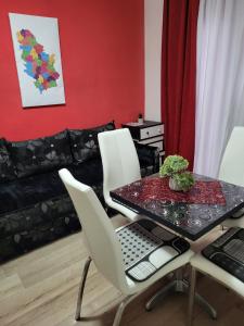 a dining room with a table and white chairs at Vila Mala Evropa in Leskovac