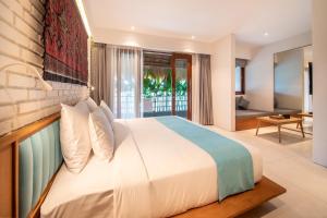 a bedroom with a large bed and a living room at IZE Canggu by LifestyleRetreats in Canggu