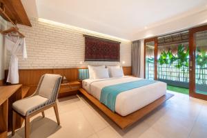 a bedroom with a bed and a desk and a chair at IZE Canggu by LifestyleRetreats in Canggu