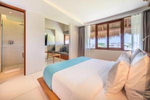 a bedroom with a large bed and a bathroom at IZE Canggu by LifestyleRetreats in Canggu