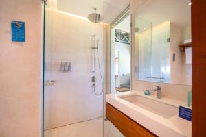 a bathroom with a shower and a sink at IZE Canggu by LifestyleRetreats in Canggu