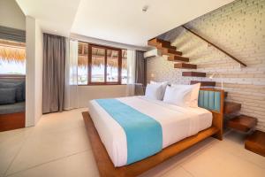 a bedroom with a large bed and a staircase at IZE Canggu by LifestyleRetreats in Canggu