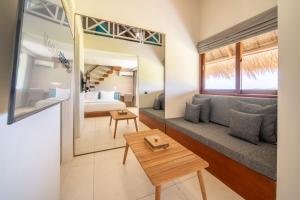 a living room with a couch and a table at IZE Canggu by LifestyleRetreats in Canggu