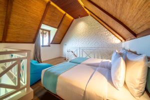 a bedroom with a large bed with a wooden ceiling at IZE Canggu by LifestyleRetreats in Canggu