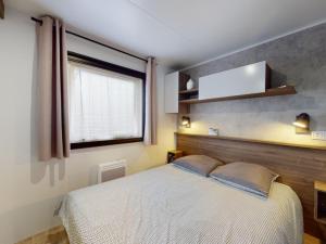 a bedroom with a white bed and a window at Mobil-Home Seignosse in Seignosse