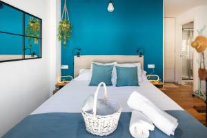 a blue bedroom with a bed with a basket on it at Casa El Palo in Málaga