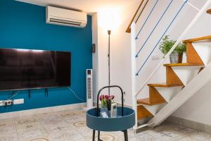 a living room with a tv and a blue wall at Casa El Palo in Málaga