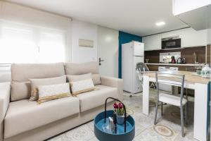 sala de estar con sofá blanco y mesa en Casa El Palo, en Málaga
