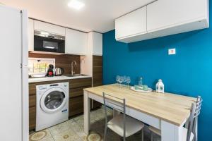 a kitchen with a table and a washing machine at Casa El Palo in Málaga