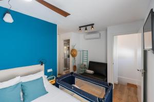 a bedroom with a bed with a blue wall at Casa El Palo in Málaga
