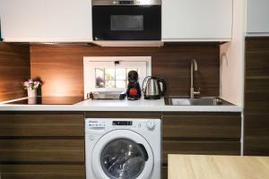 a kitchen with a washing machine and a sink at Casa El Palo in Málaga