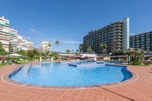 een groot zwembad in een stad met hoge gebouwen bij Playamar in Torremolinos