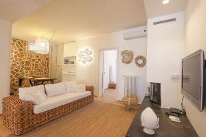uma sala de estar com um sofá e uma televisão em Trulli Dimore - Villa Fico Jo em Polignano a Mare