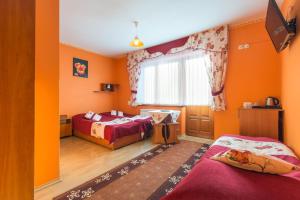 2 camas en una habitación con paredes de color naranja en Willa Stachoniówka 2, en Zakopane