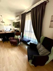 een woonkamer met een bank, een bureau en een raam bij Apartment PM in Zagreb