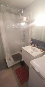 een witte badkamer met een douche en een wastafel bij "LA PERLE MARINE" Appartement, 4 personnes, balcon, vue mer et port de plaisance in Talmont