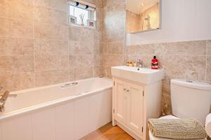a bathroom with a tub and a sink and a toilet at Belvedere Lodge, Shorefield Country Park, Shorefield Rd, Milford on Sea, Lymington SO41 0LH in Lymington