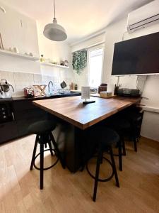 una cucina con un grande tavolo in legno con sgabelli da bar di Apartment PM a Zagabria